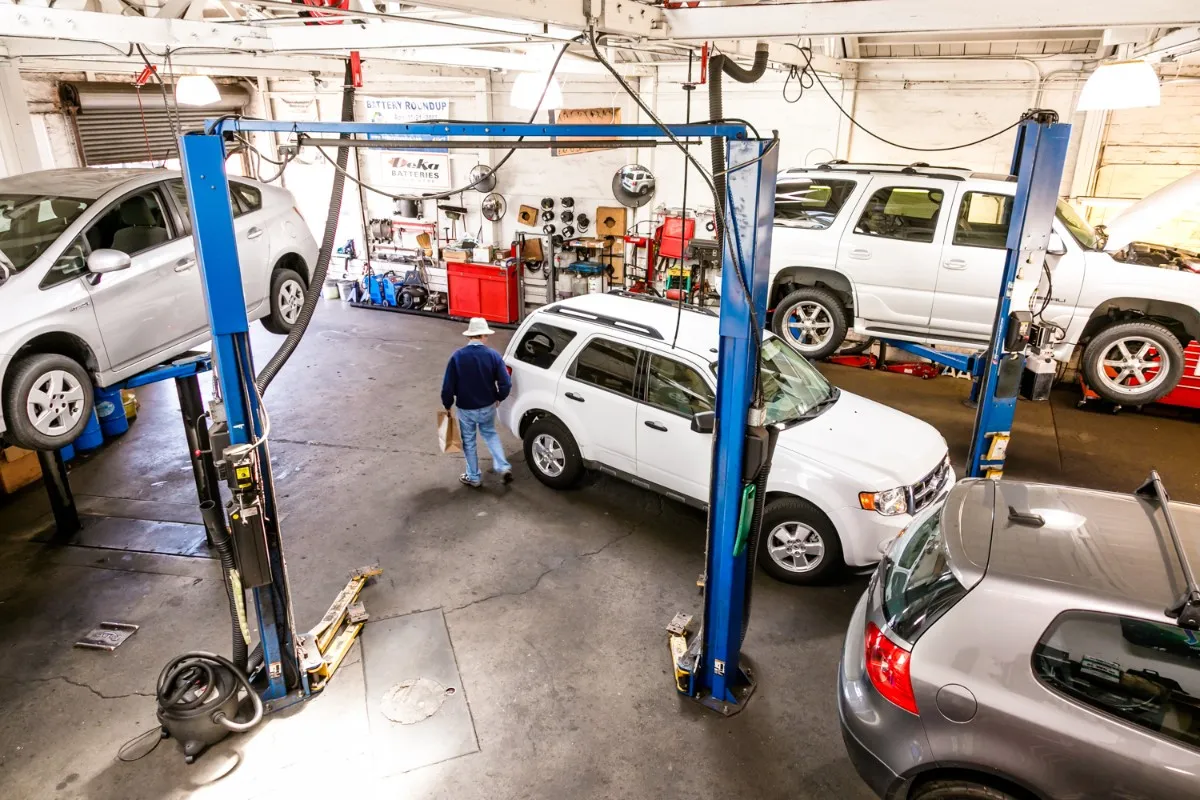 Interior of DanaMeyerAutoCare in Albany with multiple cars on lifts and a technician walking through the garage.